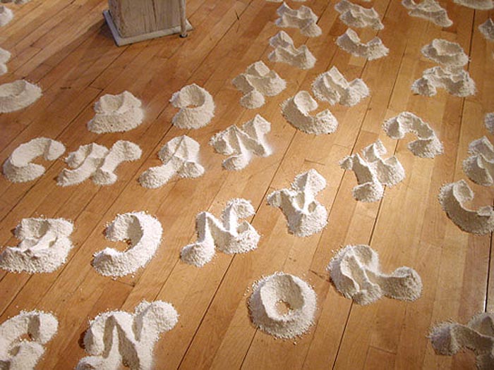 Imposed Order by David Meyer, installation with concentric circles of letters and words made from piles of flour spelling out Chance or Design, typography installation