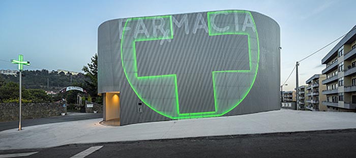 Very cool pharmacy in Portugal with neon sign incorporated into facade, farmacia lordelo in Vila Real, Portugal by Jose Carlos Cruz, Arquitecto